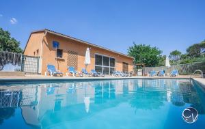 basen z krzesłami i budynkiem w obiekcie Sablières - Les terrasses de l’Ardèche w mieście Salavas