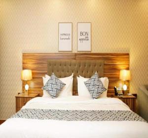 a bedroom with a bed with pillows and two lamps at Palette Luxury Credi Hotel in Riyadh