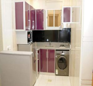 a kitchen with purple cabinets and a washing machine at Palette Luxury Credi Hotel in Riyadh +29 photos