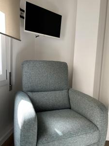 sala de estar con silla y TV de pantalla plana en Pirandello 181, en Palermo
