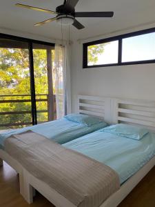 a bedroom with two beds and a ceiling fan at Diamond Hill and Beach Resort Apartment in Port Royal
