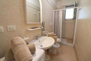 a bathroom with a sink and a toilet and a mirror at Casa Asia Otranto Beach & Center AC, WiFi & 4 Sleeps in Otranto +32 photos
