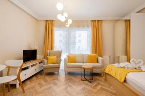 a bedroom with a bed and a couch and a tv at SKY Home-Sun Apartament -Manufaktura, Bezpłatny Parking, Dostęp na kod in Łódź