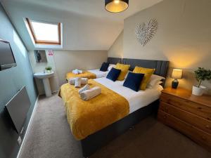 スカーバラにある45 The Square Holiday Apartments, Scarboroughのベッドルーム1室(黄色と青の枕が備わるベッド2台付)