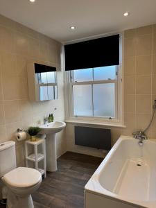 スカーバラにある45 The Square Holiday Apartments, Scarboroughの浴槽、トイレ、洗面台を備えたバスルーム