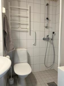 Un baño blanco con inodoro y ducha. en Quietly located one-bedroom apartment near downtown, en Jyväskylä