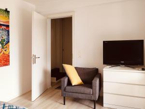 a living room with a chair and a flat screen tv at Studio near Zurich in Affoltern