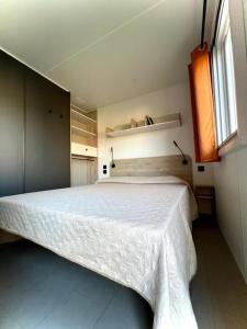 a bedroom with a large white bed in a room at Camping Village Tuscia Tirrenica in Tarquinia