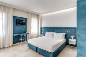 una camera da letto blu con un letto e una scrivania di Boezio 6 Rooms by Roman Dreams a Roma