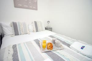 a tray with donuts and drinks on a bed at Norton Terrace Charming Home In The Beautiful Afan Forest By StayStaycations in Port Talbot