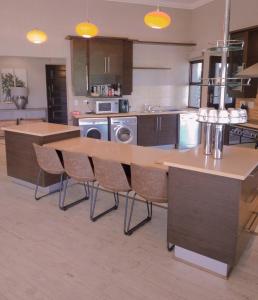 a kitchen with a wooden table and chairs at Pecanwood Relaxing Villa 5 bedroom with pool in Hartbeespoort