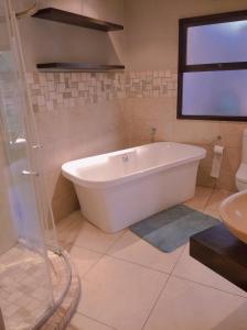 a white bath tub in a bathroom with a window at Pecanwood Relaxing Villa 5 bedroom with pool in Hartbeespoort