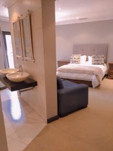 a bedroom with a bed and a sink and a bed at Pecanwood Relaxing Villa 5 bedroom with pool in Hartbeespoort