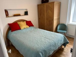 a bedroom with a bed with red and yellow pillows at L'Ancrage in Saint Malo