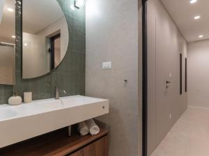 un baño con lavabo y espejo en Lemon tree apartment, en Trogir 34 fotos más
