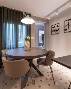 una mesa de comedor con sillas y un jarrón de flores en Lemon tree apartment, en Trogir