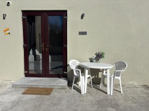 Droichead an BhuitléaraighPrivate Detached Small Bedroom and Bathroom Only- This is not an apartment- No clothes storage- no cooking facilities的门前的白色桌子和椅子