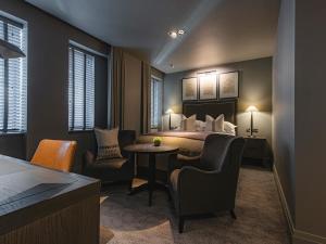 a hotel room with a bed and a table and chairs at Dakota Newcastle in Newcastle upon Tyne