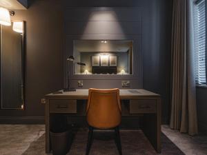 a bathroom with a desk with a mirror and a chair at Dakota Newcastle in Newcastle upon Tyne