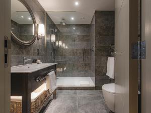a bathroom with a tub and a sink and a toilet at Dakota Newcastle in Newcastle upon Tyne
