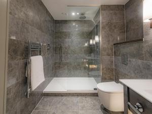 a bathroom with a bath tub and a toilet at Dakota Newcastle in Newcastle upon Tyne