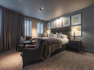 a bedroom with a bed and a chair and a table at Dakota Newcastle in Newcastle upon Tyne +107 photos