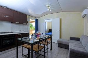 a kitchen and living room with a table and a couch at Camping Village Tuscia Tirrenica in Tarquinia