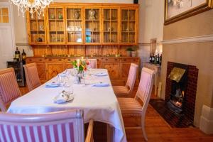 a dining room with a table and chairs and a fireplace at Bakenskraal Ostrich Palace in Oudtshoorn