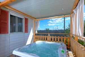 a hot tub on the balcony of a house at Camping Village Tuscia Tirrenica in Tarquinia