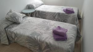 two purple mitts on a bed in a room at Casa Roc de Sant Gaietà in Comarruga +5 photos