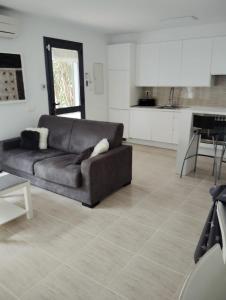 a living room with a couch and a kitchen at Casa Roc de Sant Gaietà in Comarruga