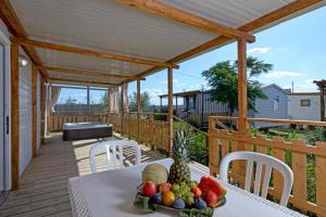 a table with a plate of fruit on a deck at Camping Village Tuscia Tirrenica in Tarquinia