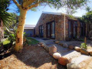 a stone house with a tree in front of it at 29 on Edward - 4 bedroom House in Cape Town