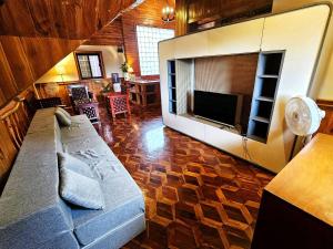 Una sala de estar con un sofá y un televisor de pantalla plana. en Attic Room 3B Transient Baguio Wifi Parking, en Baguio
