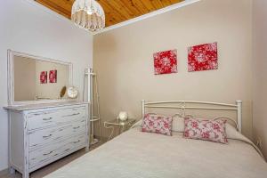 Un dormitorio con una cama, una cómoda y un espejo. en Leni's Lake Living, en Halikounas