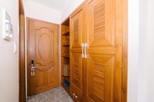 a closet with wooden cabinets and a door at Đoàn An điều dưỡng 198 in Xuan An