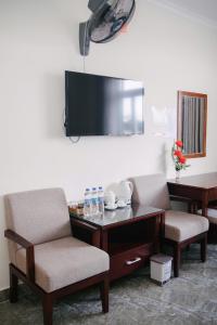 a room with two chairs and a table and a tv at Đoàn An điều dưỡng 198 in Xuan An