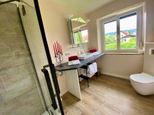 a bathroom with a sink and a toilet and a shower at Ferienwohnung Altes Zollhaus in Ering +39 photos