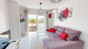 a living room with a purple couch and red pillows at Holidoo Travel Casa Dorada in Los Alcázares