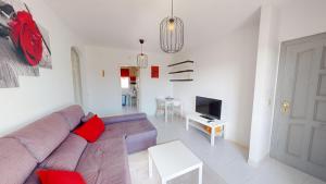 a living room with a couch and a tv at Holidoo Travel Casa Dorada in Los Alcázares