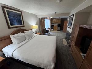 a hotel room with a bed and a television at Promenade Inn & Suites Oceanfront in Seaside