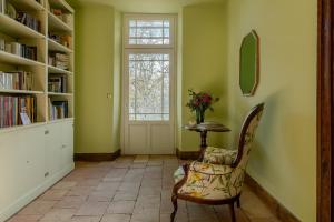 a room with a chair and a table and a window at La Reverdie in Cahuzac-sur-Vère