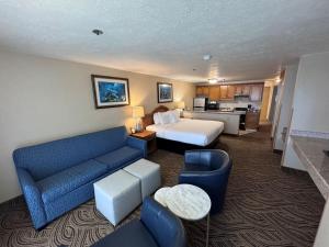 a large hotel room with a bed and a couch at Promenade Inn & Suites Oceanfront in Seaside