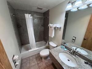 a bathroom with a sink and a toilet and a tub at Promenade Inn & Suites Oceanfront in Seaside
