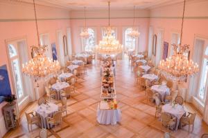 um salão de banquetes com mesas e lustres numa sala em Hotel Bernina 1865 em Samedan