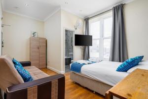 a bedroom with a bed and a couch and a window at Camden Apartments in London