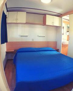a bedroom with a blue bed in a room at Camping Village Tuscia Tirrenica in Tarquinia