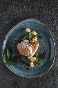a blue plate with a piece of food on it at Bio-Landhotel Moarwirt in Dietramszell