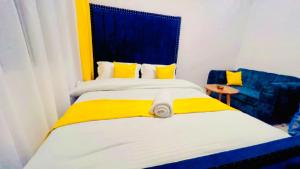 a bedroom with two beds and a blue chair at Kozy Homes in Nairobi
