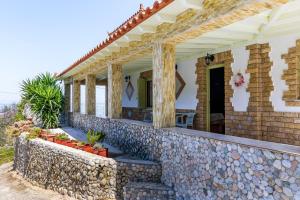 a house with a stone wall at Nerissa Cottage - Skopelos Glossa in AthÃ©aton